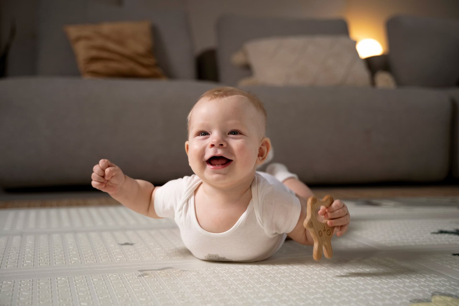 Bebé haciendo tummy time sobre una manta, levantando la cabeza y fortaleciendo cuello y espalda durante el juego supervisado.