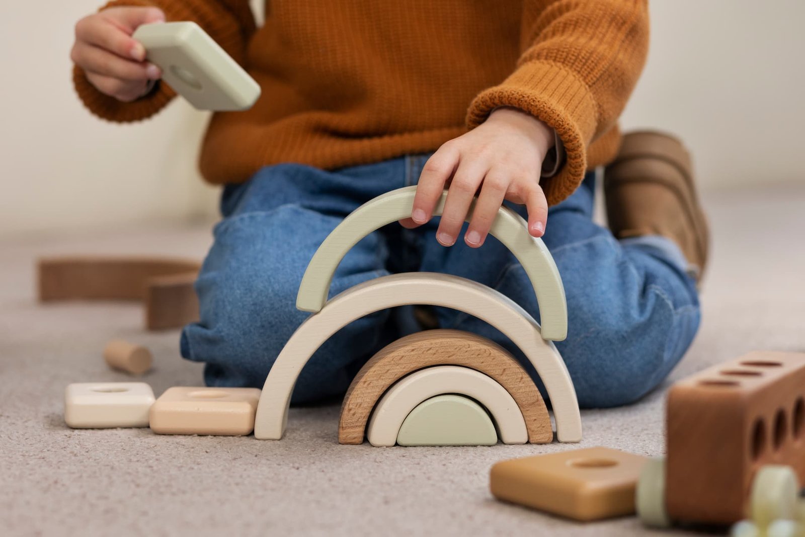 Niño jugando con bloques de colores que estimulan la motricidad, mejorando su coordinación y desarrollo motor.